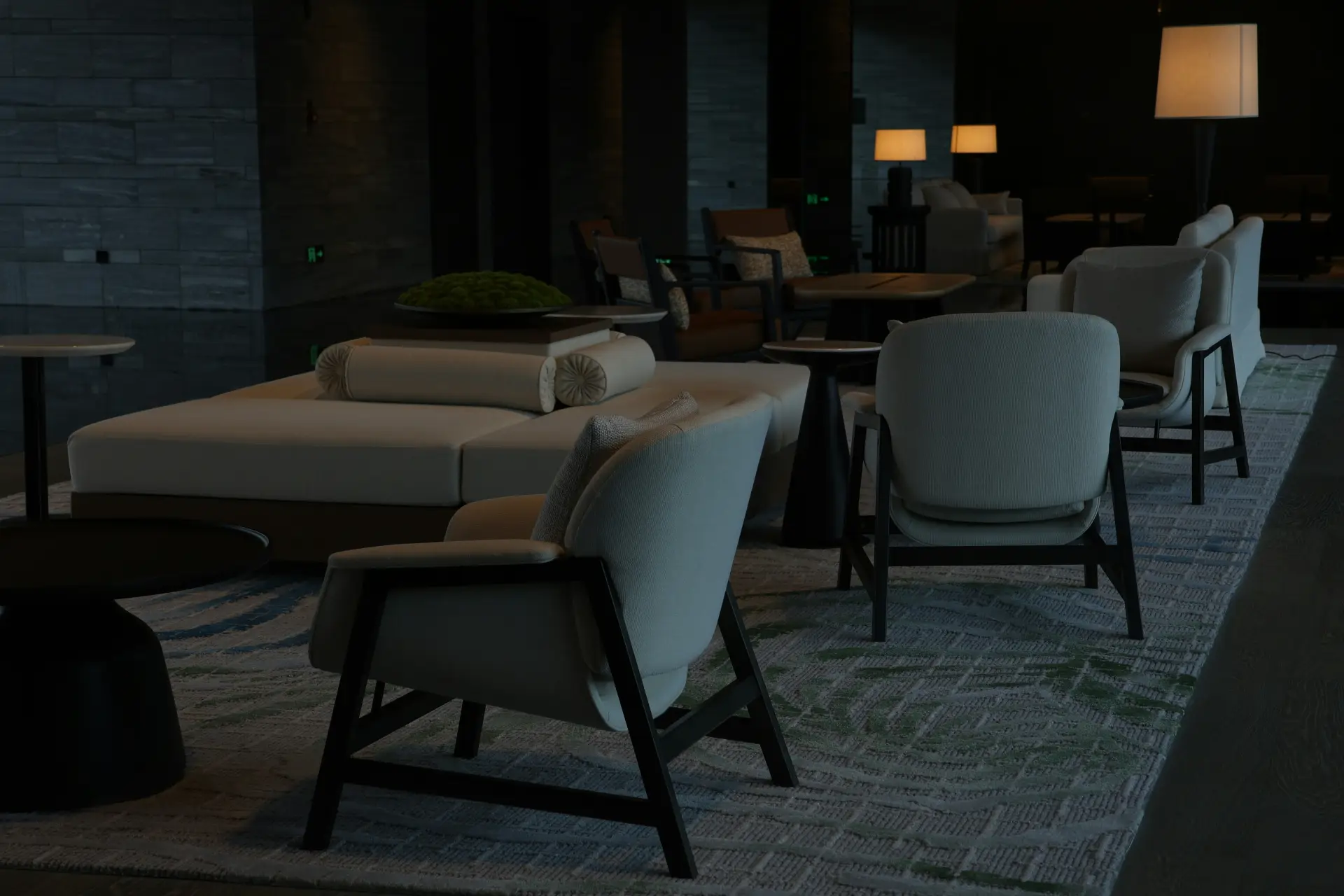 A quiet hotel lounge with armchairs and low lamplight